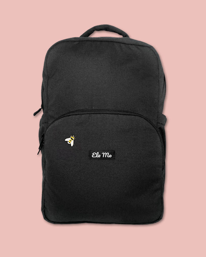 Ela Mo™ Mini Pin für Rucksäcke | Biene. Ein kleiner Pin ist vorne am schwarzen Rucksack befestigt.