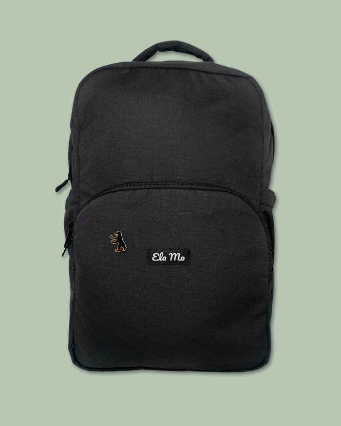Ela Mo™ Pin für Rucksäcke – Berlin | Auf schwarzem Rucksack vor hellgrünem Hintergrund