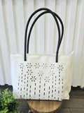 Leather tote bag with floral detail.