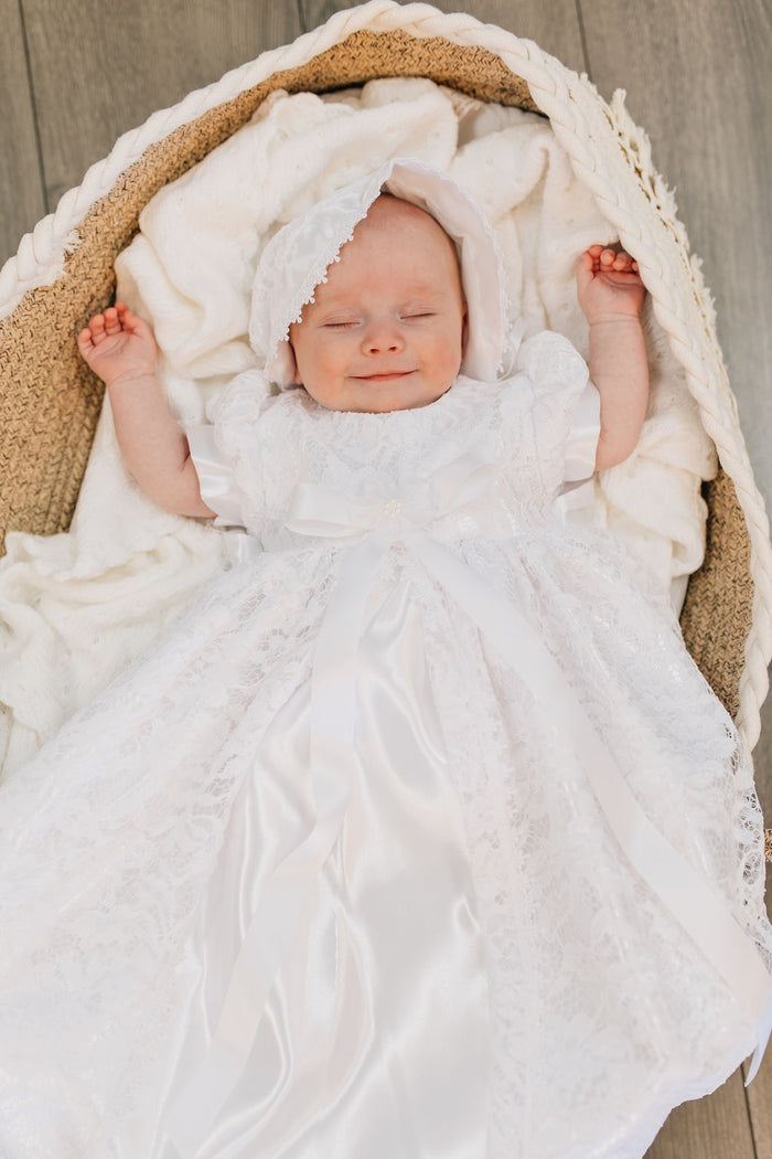 Long white lace and satin baby gown with bow.