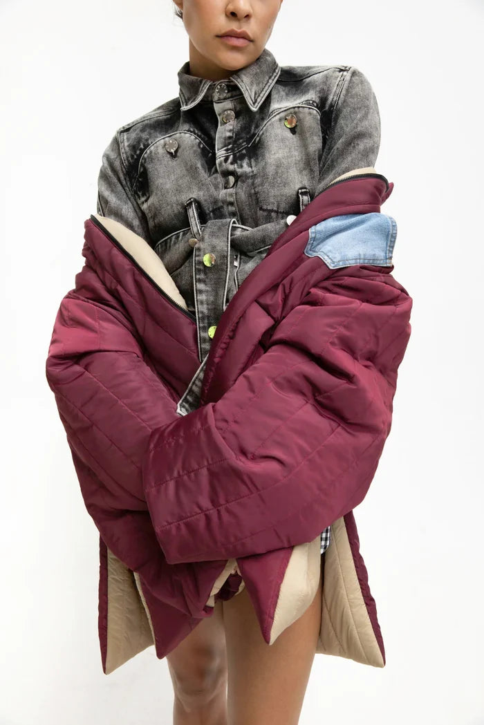 MANCANDY Utility Quilted Coat in blue nylon featuring oversized quilted construction, high side slits, contrast denim chest pocket, embroidered sleeve patch and front zip closure.